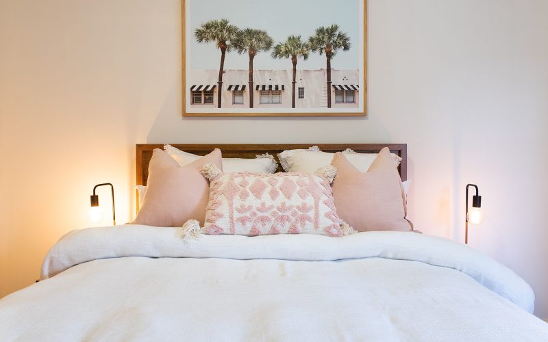 Small bedroom bed with white bed linen and pink color pillows
